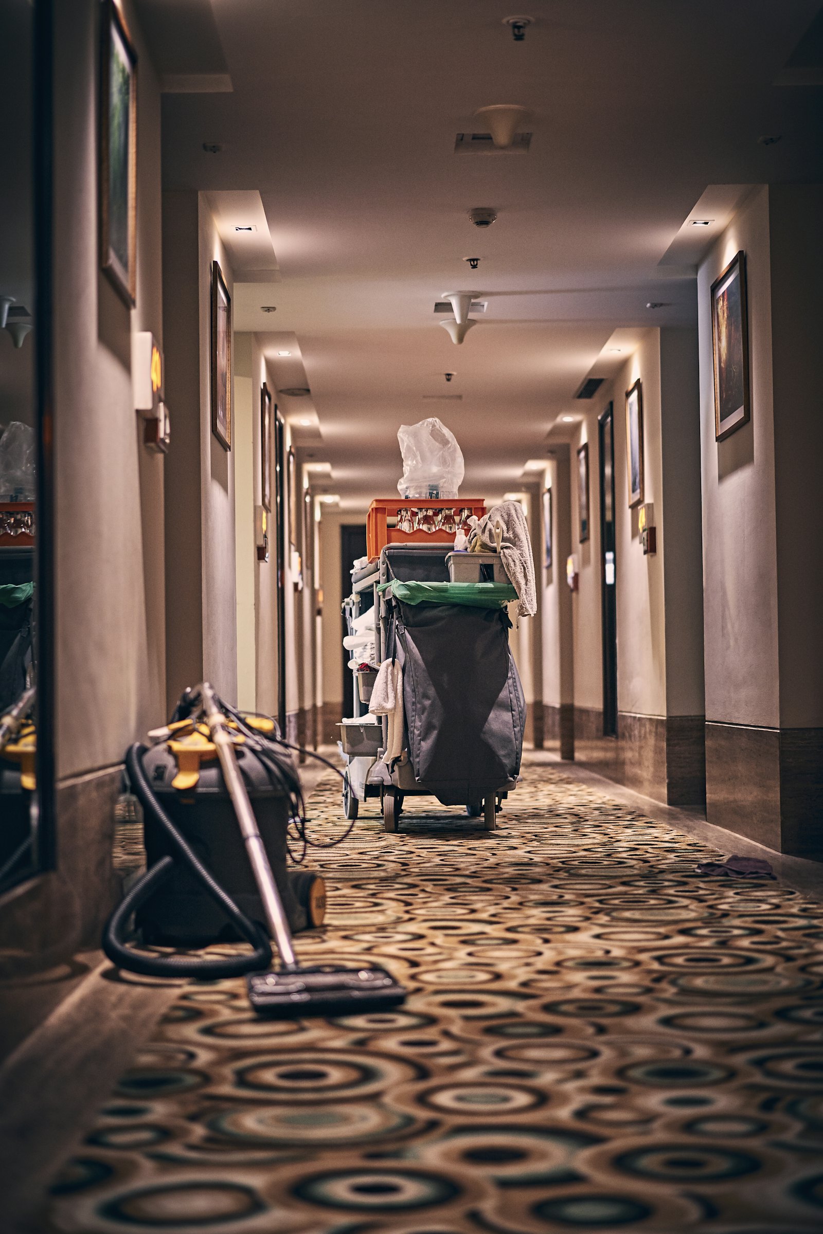Housekeeping trolley and vacuum in a hotel corridor