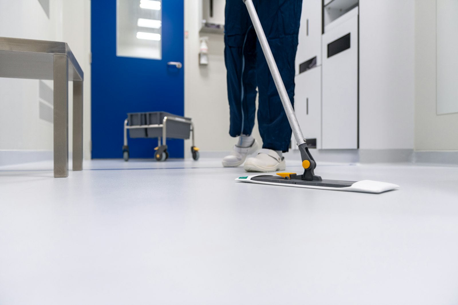 Cleaner mopping a clinic corridor